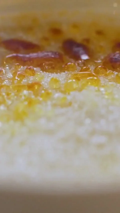 Sugar melts and bubbles into caramel on creme brulee Stock Footage 334168925