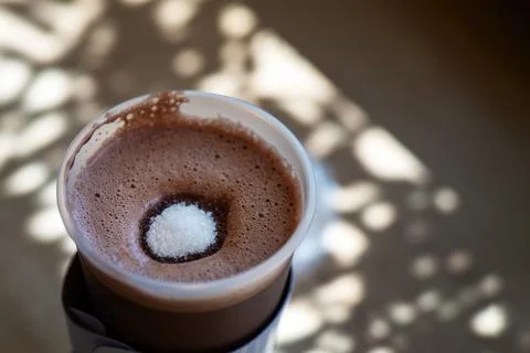 Sugar mound dissolves in a steaming glass of cocoa, symbolizing the fusion of Stock Photos