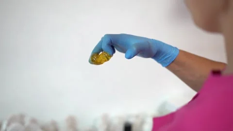 Sugar paste on a hand in blue glove. Poster, copy space. Sugaring salon Stock Footage 251650051