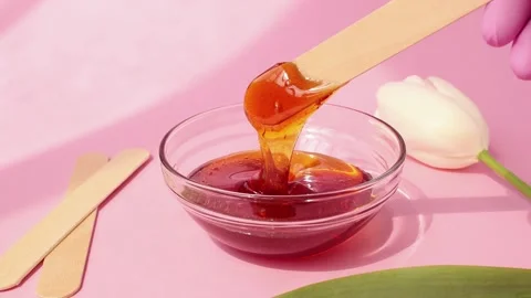 Sugar paste for shugaring on a pink background. Stockbeeldmateriaal 153101684