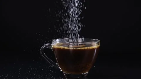Sugar Pouring into Tea Cup on Black Background 库存影片 312249900