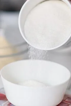 Sugar pours into the container close-up Stock Photos