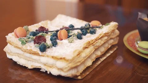 Sugar powder cake with berries, mint and candy on table with bakery products Video stock 77162251