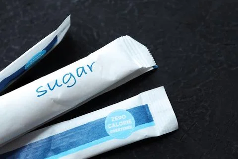Sugar sachet packaging on a black background.  Stock Photos