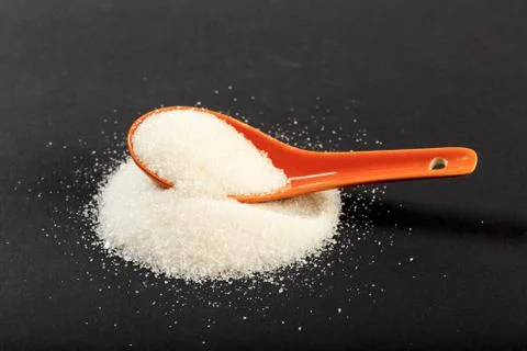 Sugar with spoon  on black background - Image Stock Photos