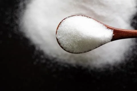 Sugar on spoon top view, texture small pelledts refined sugar organic Stock Photos