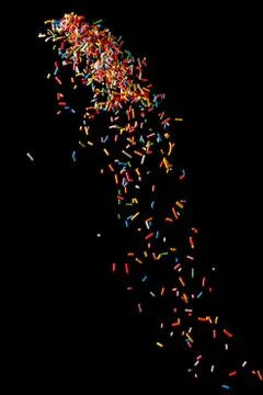 Sugar sprinkle dots on a black background. Stock Photos