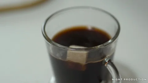 Sugar stone falling into a cup of coffee in slow-motion (200fps) 스톡 동영상 124468922