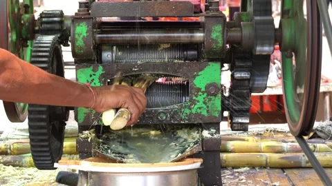 Sugarcane Juice Extraction Machine in Traditional Indian Street Stall Stock Footage 336884663
