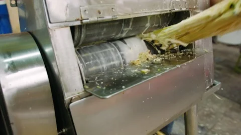 Sugarcane juice extractor machine pressing fresh stalks to make a tradition.. Stockbeeldmateriaal 336985885