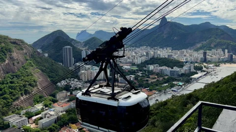 Sugarloaf Cable Car Ascending Toward Morro da Urca with Corcovado Mountain in Stock Footage 328141581