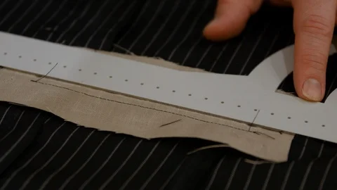 Suit designer putting cut marks for tuxedo pocket. Most jackets have a variety Stock Footage 127256613