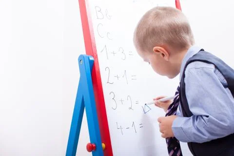 Suit up small young boy working on the chalkboard Stock Photos