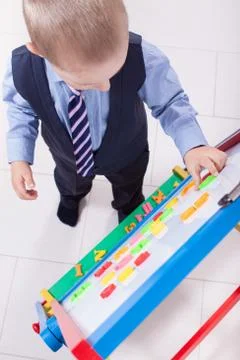 Suit up small young boy working on the chalkboard Stock Photos