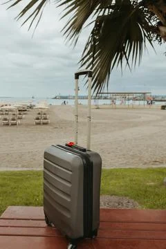 Suitcase on bench with beach background Foto stock