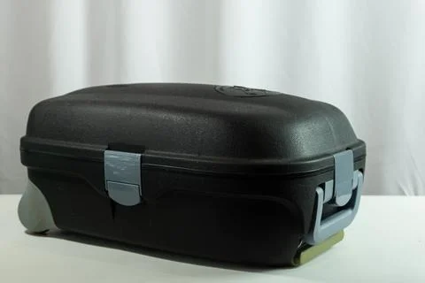 Suitcase lying flat on white textured surface, travel-themed shot capturing.. Stock Photos