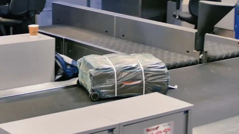 Suitcase Packed in plastic goes in the cargo area Stock Footage 73314101