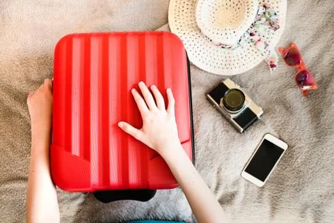 Suitcase with packed summer clothes, a camera, a hat and sunglasses Foto stock