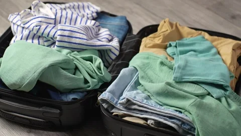 Suitcase Packing. Clothes fall into suitcase close-up. Open suitcase full o.. Stock Footage 275592839