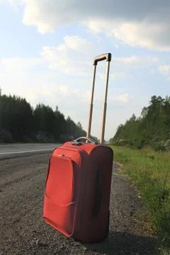 Suitcase on the road Stock Photos