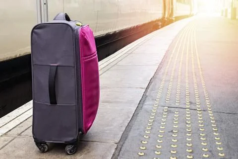 Suitcase standing on the train platform Stock Photos