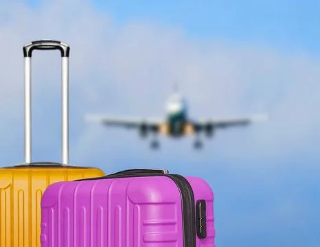 Suitcases and the blure boarding plane in the blue sky. Stock Photos
