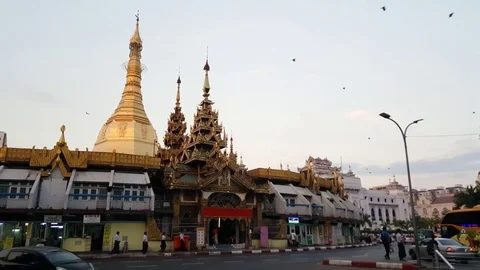 Sule Pagoda side angle shot, Yangon street, pedestrians, traffic, pigeons fly Video stock 80914115