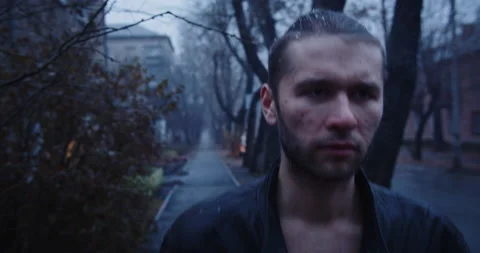 Sullen young man walks down the street during the snow with a crumpled face in a Video stock 170440101