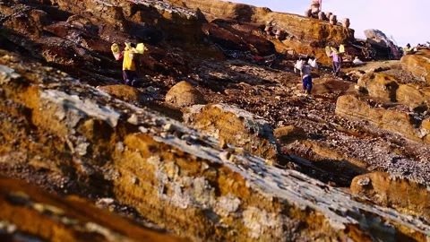 Sulphur miners of East Java hard work carry heavy baskets of sulfur Stock Footage 221873024