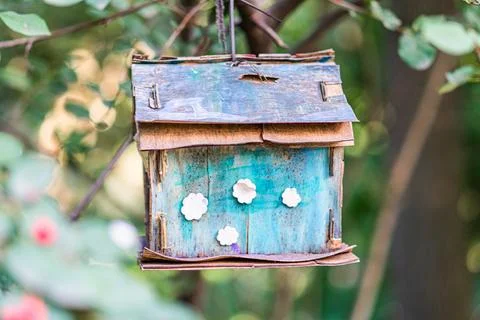 Summary of Image Description A weathered green and blue birdhouse hangs sligh Stock Photos