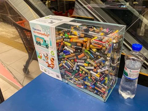 Summary Table with open clear plastic box containing assorted batteries for r Stock Photos
