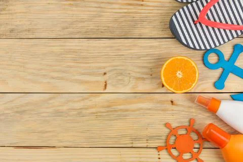 Summer accessories. beach accessories. sunscreen, flip flops, and orange on a Stock Photos