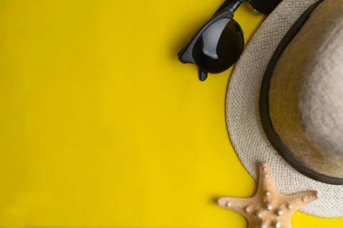 Summer accessories, sea shell, hat and sun glasses on yellow background. Summ Stock Photos