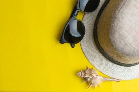 Summer accessories, sea shell, hat and sun glasses on yellow background. Summ Stock Photos
