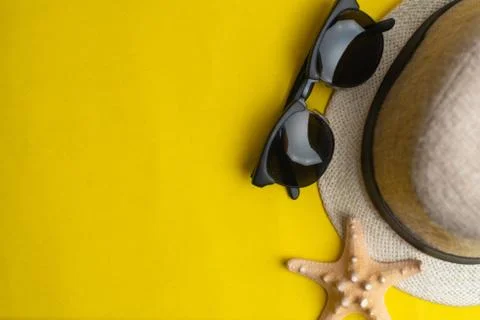 Summer accessories, shells, hat and sun glasses on yellow background. Summer  Stock Photos