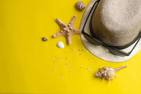 Summer accessories, shells, hat and sun glasses on yellow background. Summer  Stock Photos