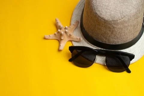 Summer accessories, shells, hat and sun glasses on yellow background. Summer  Stock Photos