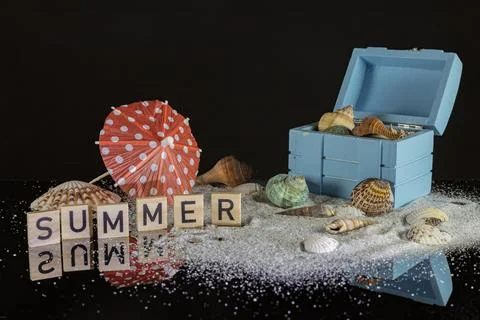 Summer background with blue box, seashells, starfish and umbrella Stock Photos