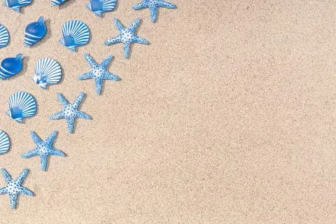 Summer background with blue seashell pattern on beach sand background. Cop... Stock Photos