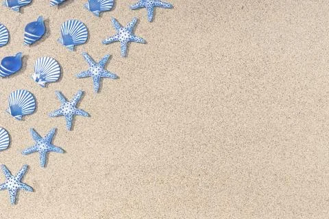 Summer background with blue seashell pattern on beach sand background. Copy Stock Photos