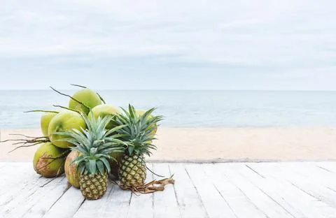 Summer background, coconuts and pineapples on white wood table Stock Photos