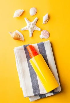 Summer background. Seashells, sunscreen on a yellow background. Stock Photos