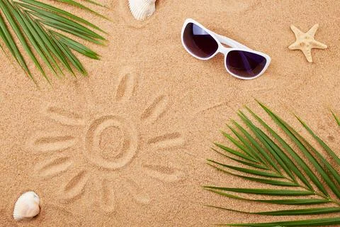 Summer background. Sunglasses, shells and palm leaves on the sand on the beac Stock Photos