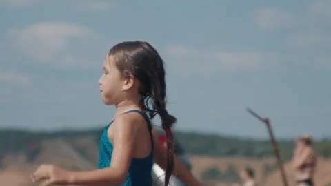 Summer beach and fun. Kids have fun and jump into the river from the sandy beach Stock Footage 344953889