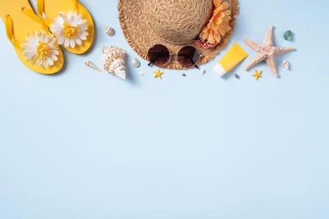 Summer beach background design concept with shells, hat, slipper on yellow ba Stock Photos