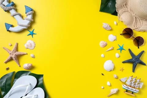 Summer beach design concept with shells, hat, slipper on yellow background. Stock Photos