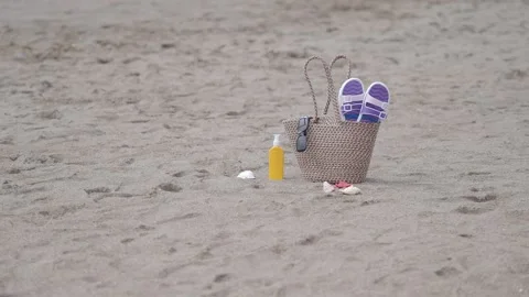 Summer Beach Essentials: Bag, Sandals, Sunscreen, and Seashells on Sand Stock Footage 335500783
