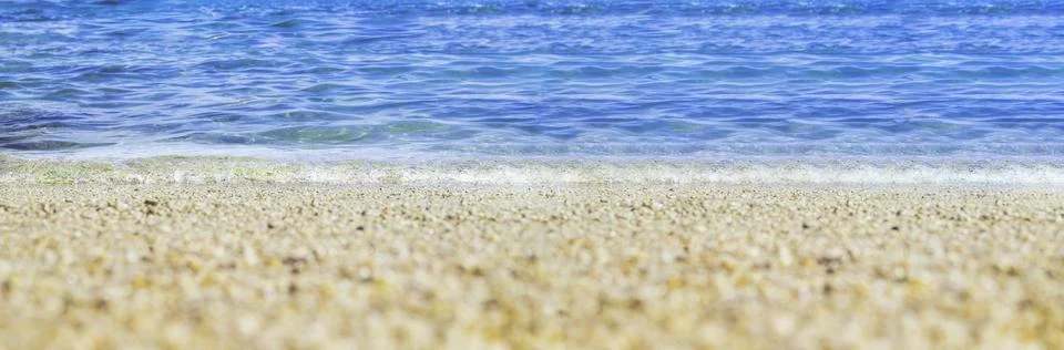 Summer beach low angle view background.Close up wave of blue sea on sand beac Stock Photos