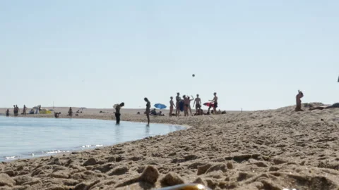 Summer Beach Scene With People on Sandy Shoreline and Umbrellas Near Calm Ocean Video stock 338433520
