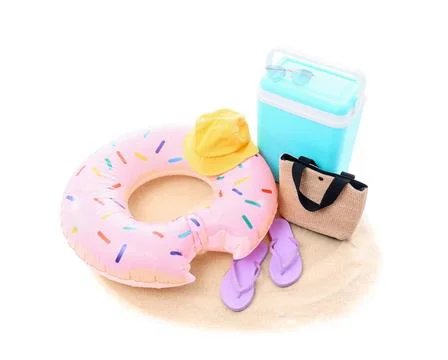 Summer beach vacation essentials with donut inflatable ring, cooler, hat, bag Stock Photos